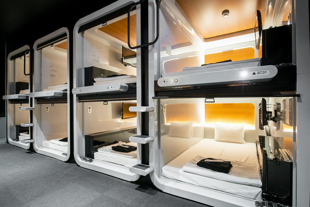A plain corridor lined with identical compact sleeping units.