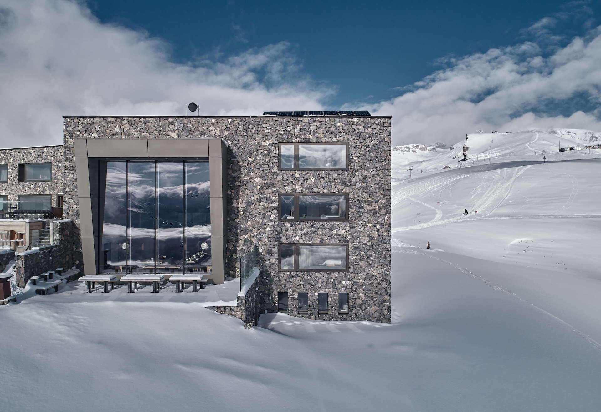 A concrete building on an open mountain slope above a valley.