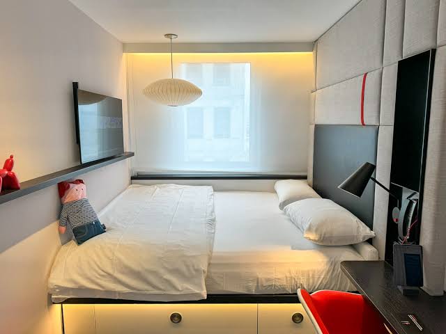 A fitted compact room with a bed built wall to wall.