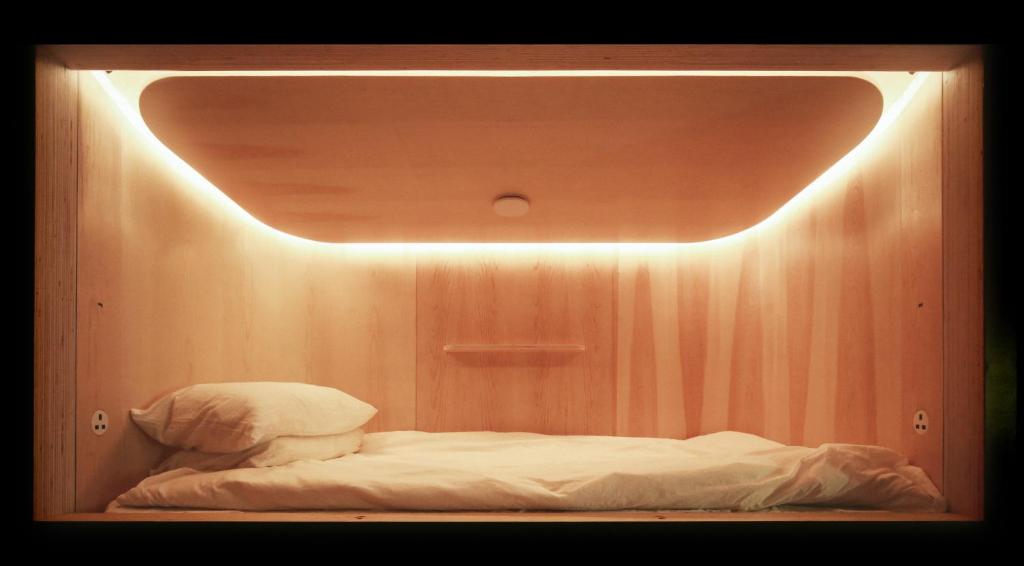 Closed sleeping cabins arranged in rows inside a plain room.
